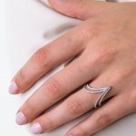 Elegancko ubrana modelka prezentuje pierścionek z białego złota z diamentami