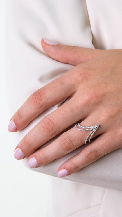 Elegancko ubrana modelka prezentuje pierścionek z białego złota z diamentami