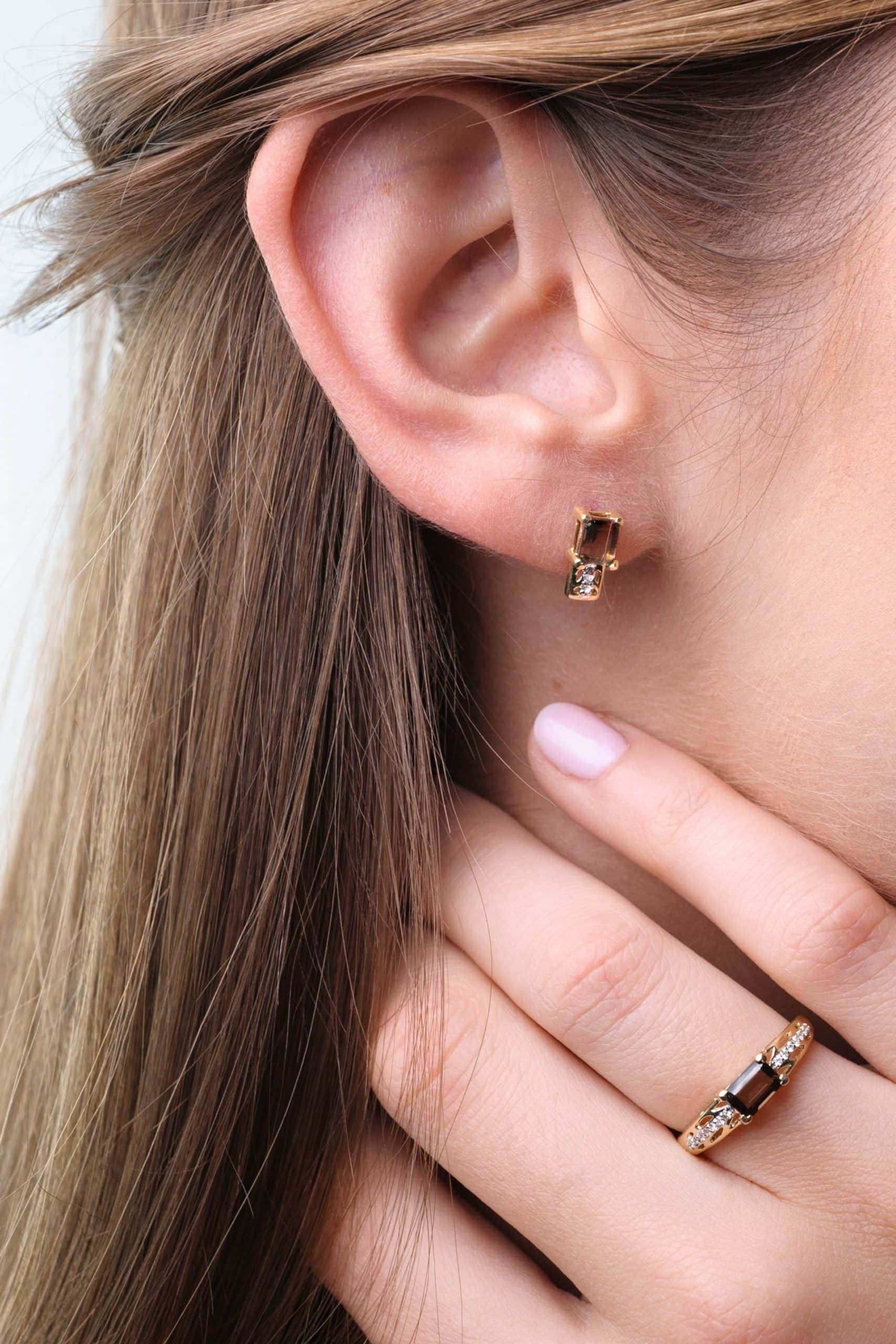 Gold earrings with smoky quartz and diamonds on a model