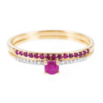 Gold rings with diamonds and rubies on white background.