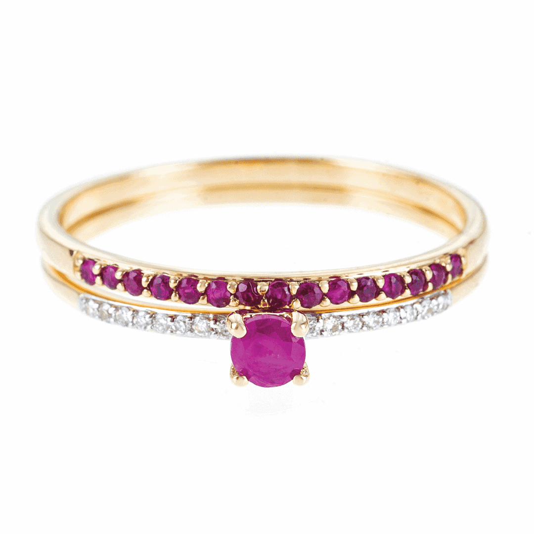 Złote pierścionki ułożone jeden na drugim wykonane ze złota z różowymi rubinami i białymi diamentami