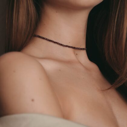 Modelka prezentuje na sobie czerwony choker z granatów