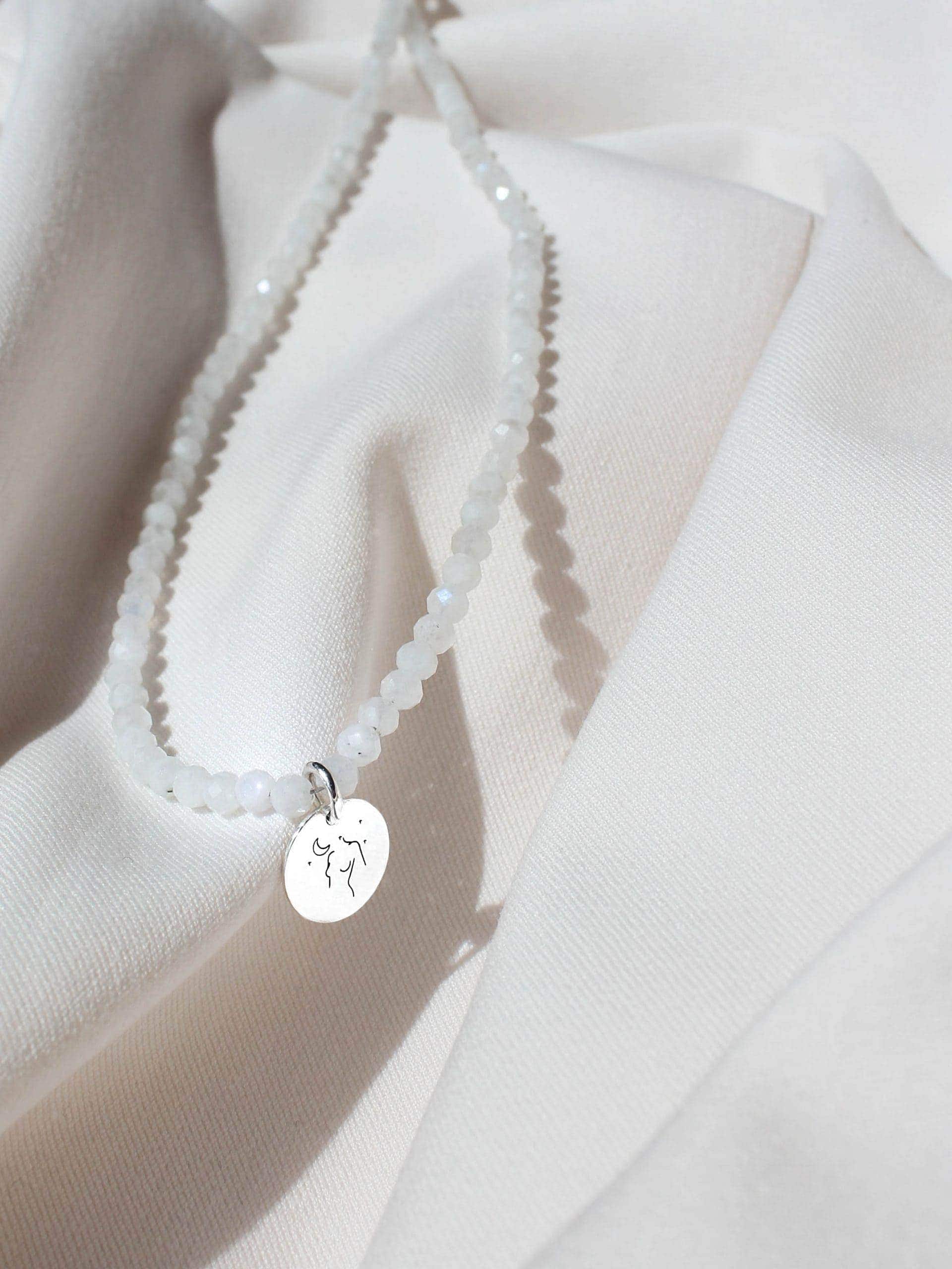 Moonstone necklace with silver pendant on white material