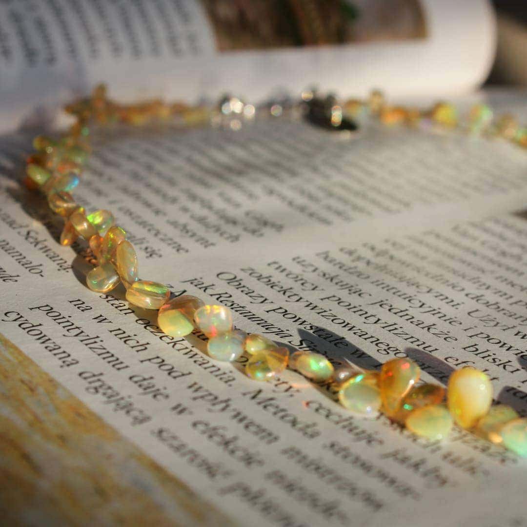 Gemstones necklace from natural opals on art book