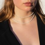 Naszyjnik z kamieniem księżycowym oraz choker z pereł na modelce