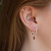 Srebrne kolczyki koła z zawieszką GARNET DROP na modelce.