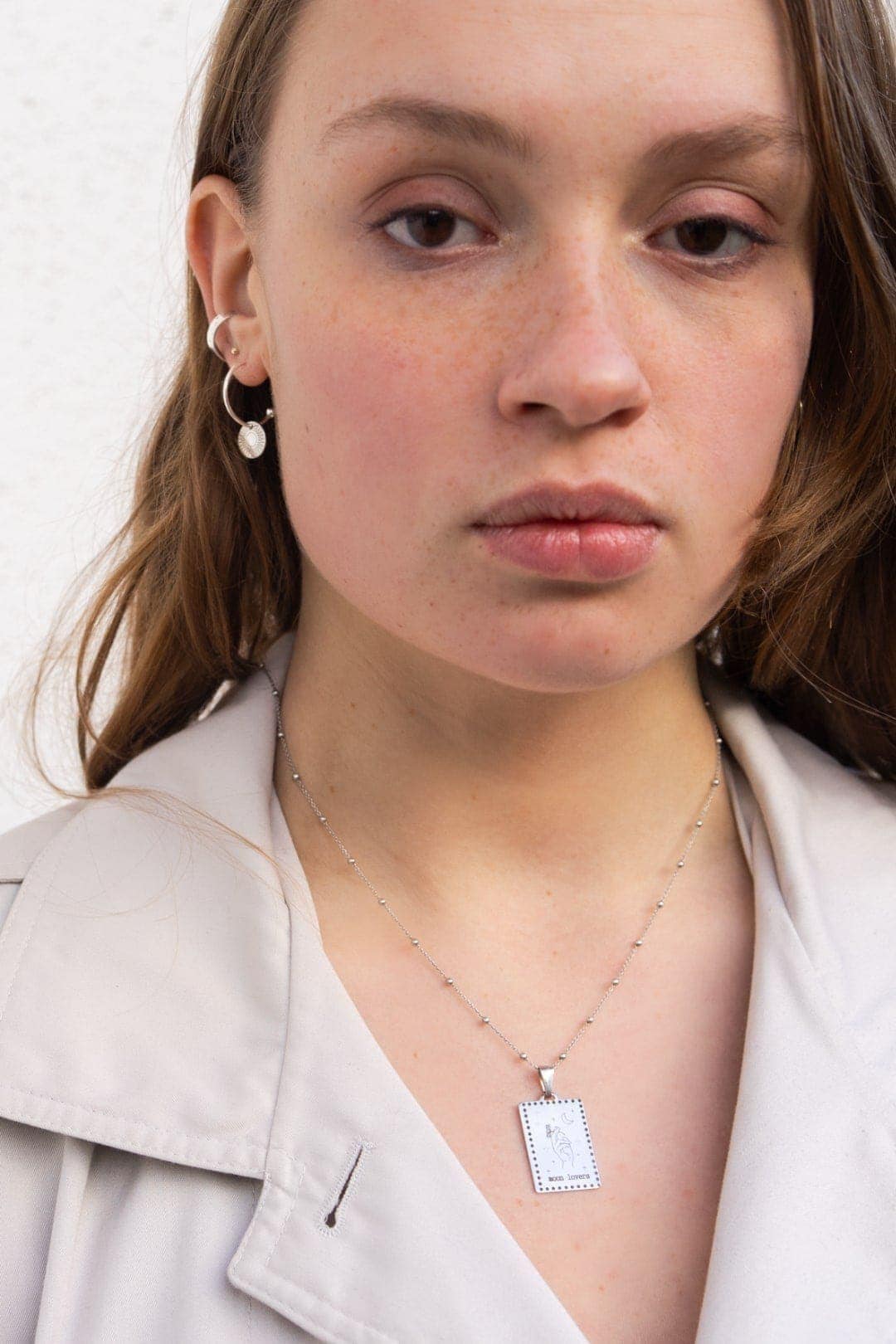 Silver blade necklace with engraving and hoops earring on model.