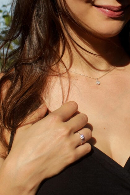 Modelka prezentuje złoty pierścionek zaręczynowy z diamentem.