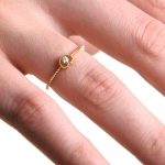 Modelka prezentuje złoty pierścionek z diamentem w formie serca