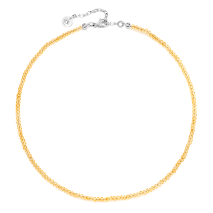 Żółty naszyjnik z kamieni cytrynów na jasnym tle.