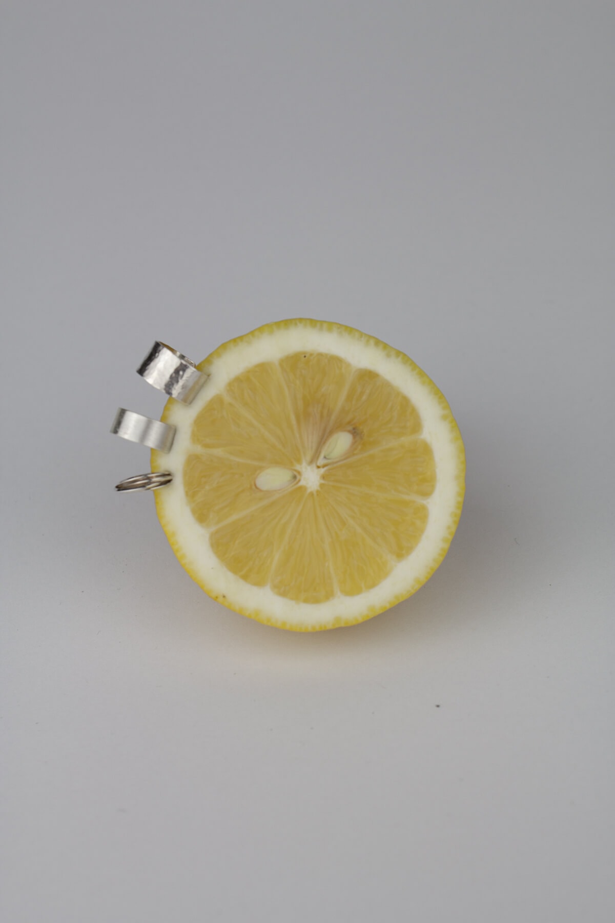 Silver ear cuffs on a lemon and gray background