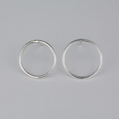 Silver circle earrings on bright background.