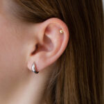 Małe srebrne kolczyki huggie na modelce
