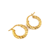 Złote kolczyki koła 585 na jasnym tle.