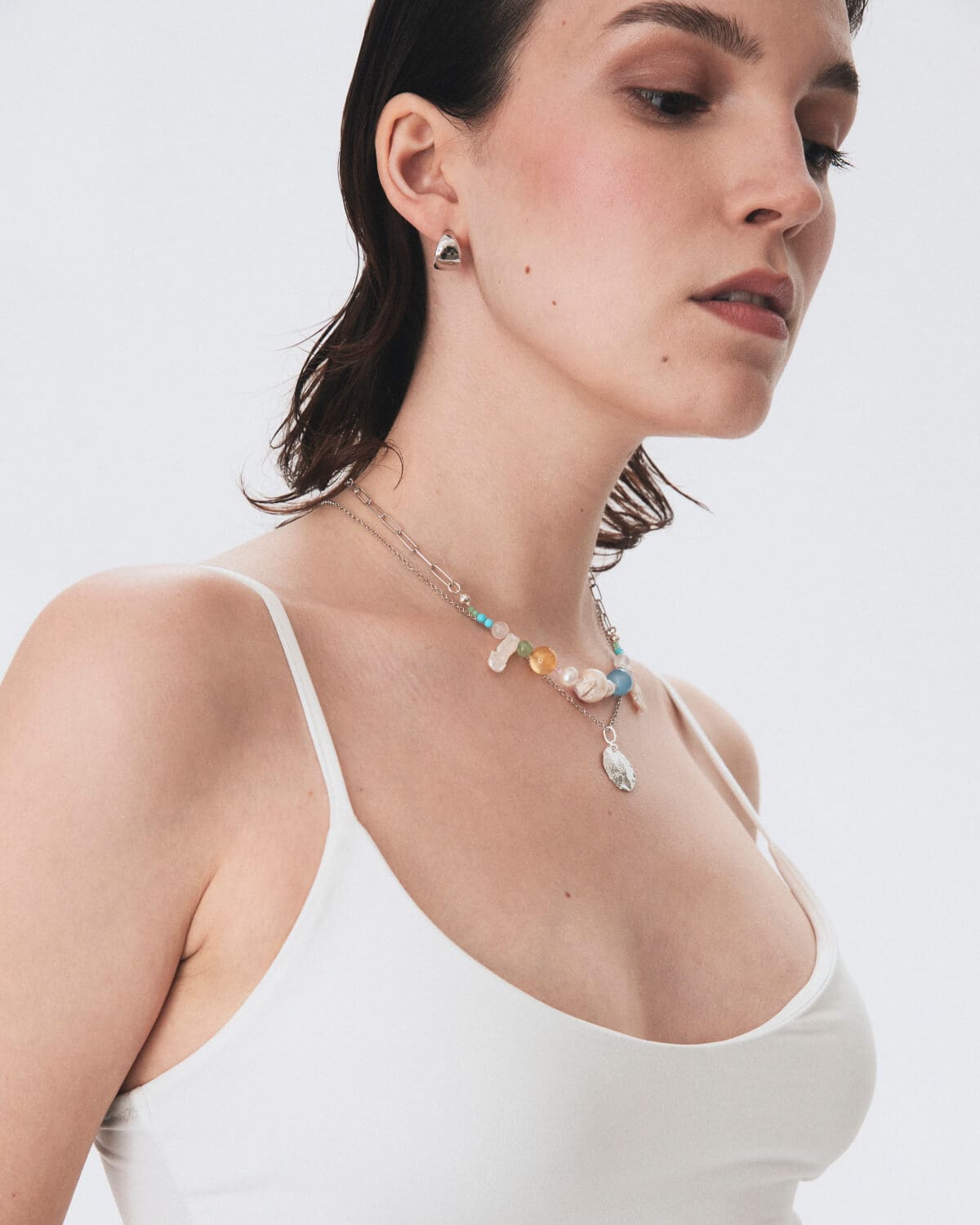 Fashionable necklaces with pearls and colored stones on model