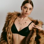 Wiszące kolczyki z zawieszką perłą koła oraz naszyjnik z dużymi zawieszkami na modelce ubranej w futro