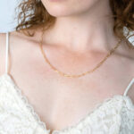 Pozłacany srebrny naszyjnik ankier i duże kolczyki na modelce.