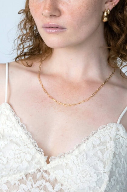 Pozłacany srebrny naszyjnik ankier i duże kolczyki na modelce.